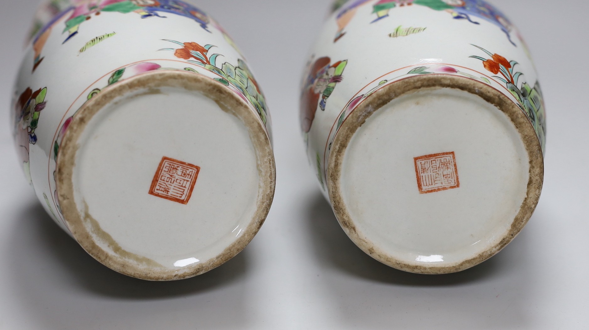 A pair of Chinese Famille Rose ‘boys’ vases, 25cms high